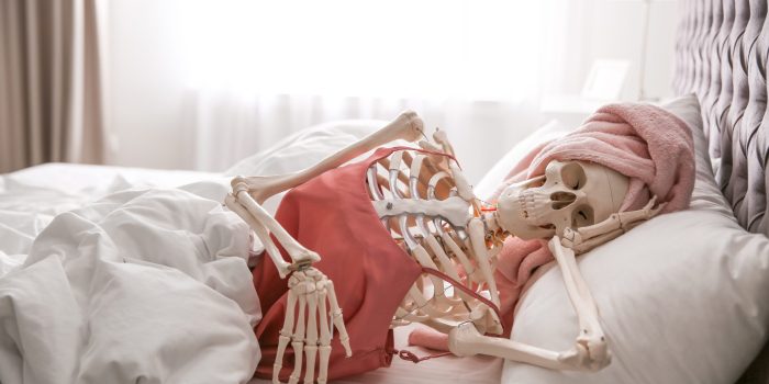 Human,Skeleton,In,Silk,Pajamas,And,Towel,Lying,On,Bed